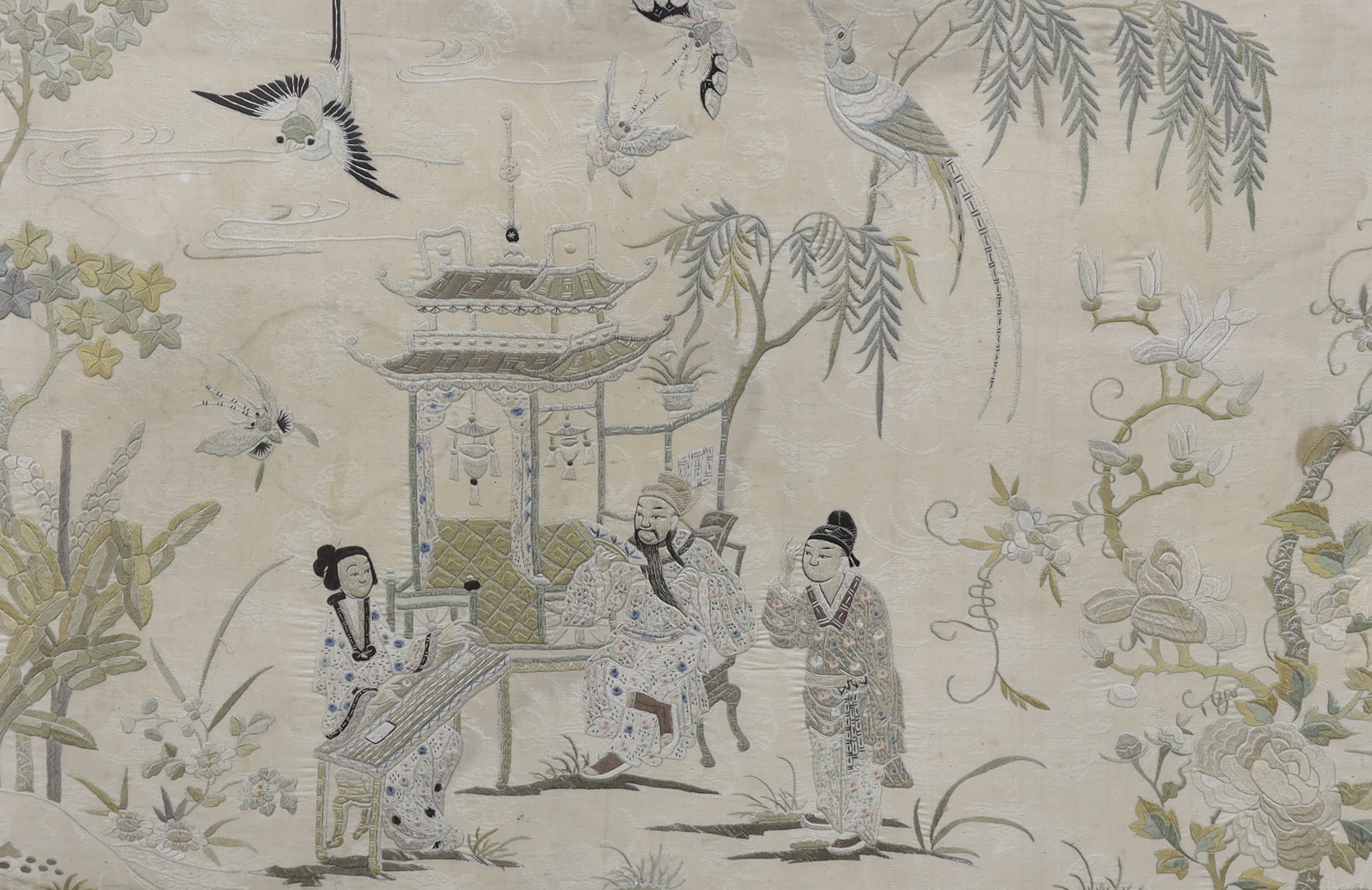 A late 19th century Chinese embroidered silk panel depicting noblemen and attendants in a garden, 44 x 70cm